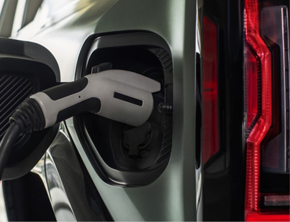 Close up of charging port with charger plugged in on a GMC Hummer EV SUV - Tri State Motors in CEDAR CITY UT